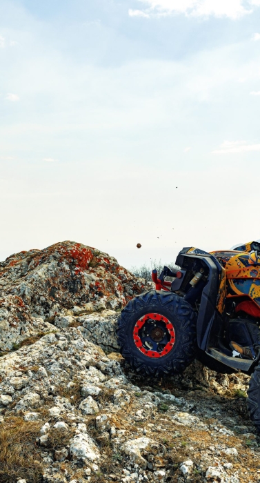 Man in helmet sitting on ATV quad bike in mountains on race